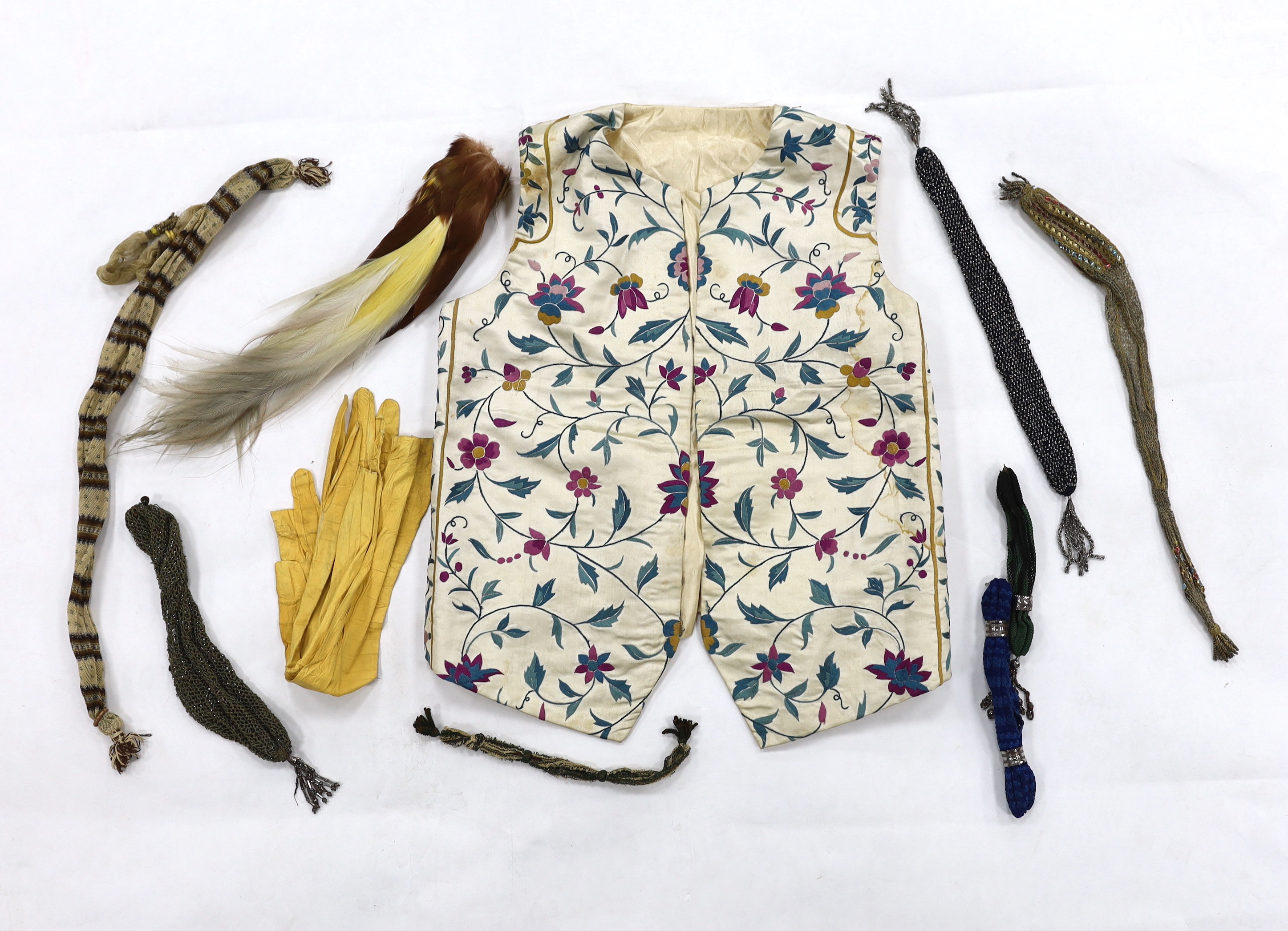 A collection of eight late 18th / early 19th century cut steel and other misers purses, a pair of yellow Regency ladies long shami leather gloves, an exotic feather hat ornament and a Chinese embroidered young boys waist
